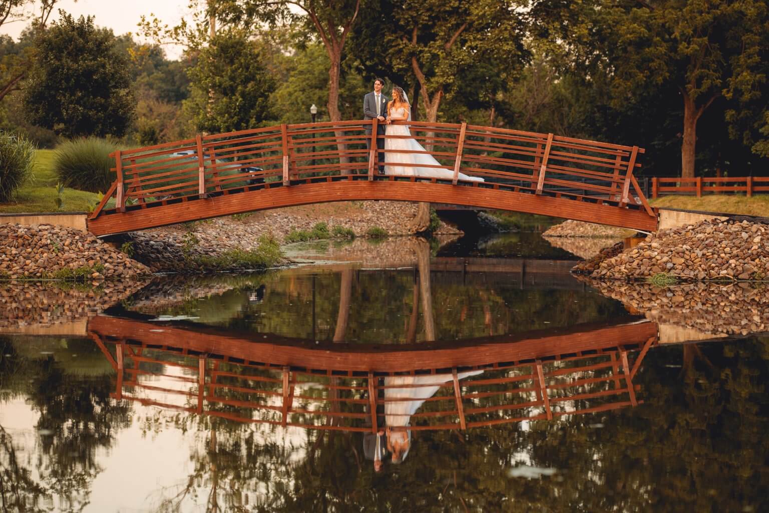 Bride and groom mirrored in the still water