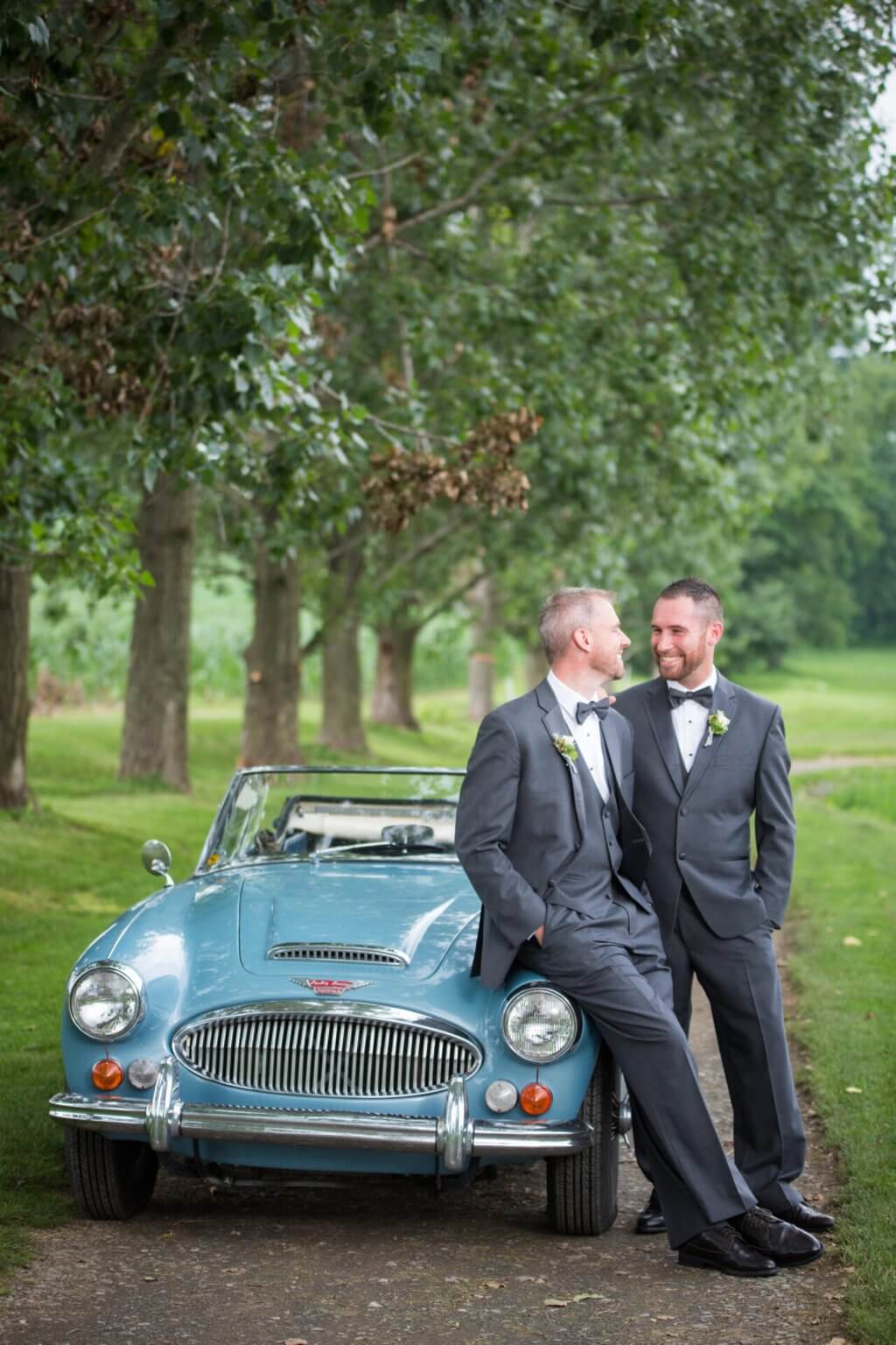 Two grooms and a vintage Healey on the path