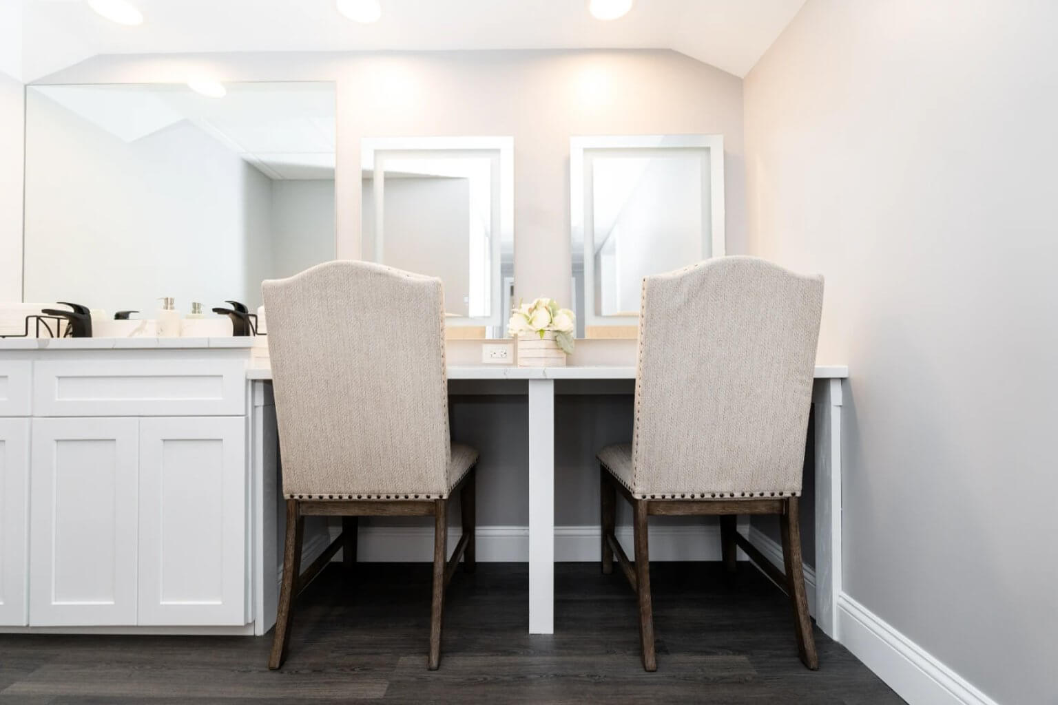 Lit mirrors and soft chairs along the vanity